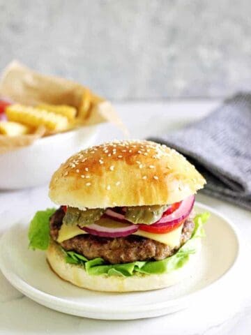 Homemade beef burger with fries in the background