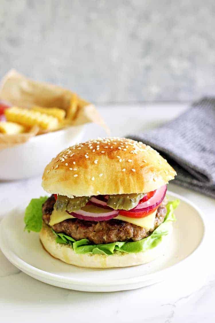 Homemade beef burger with fries in the background