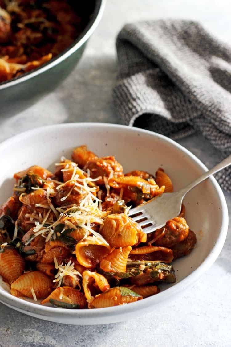 Fork in bowl of sausage pasta
